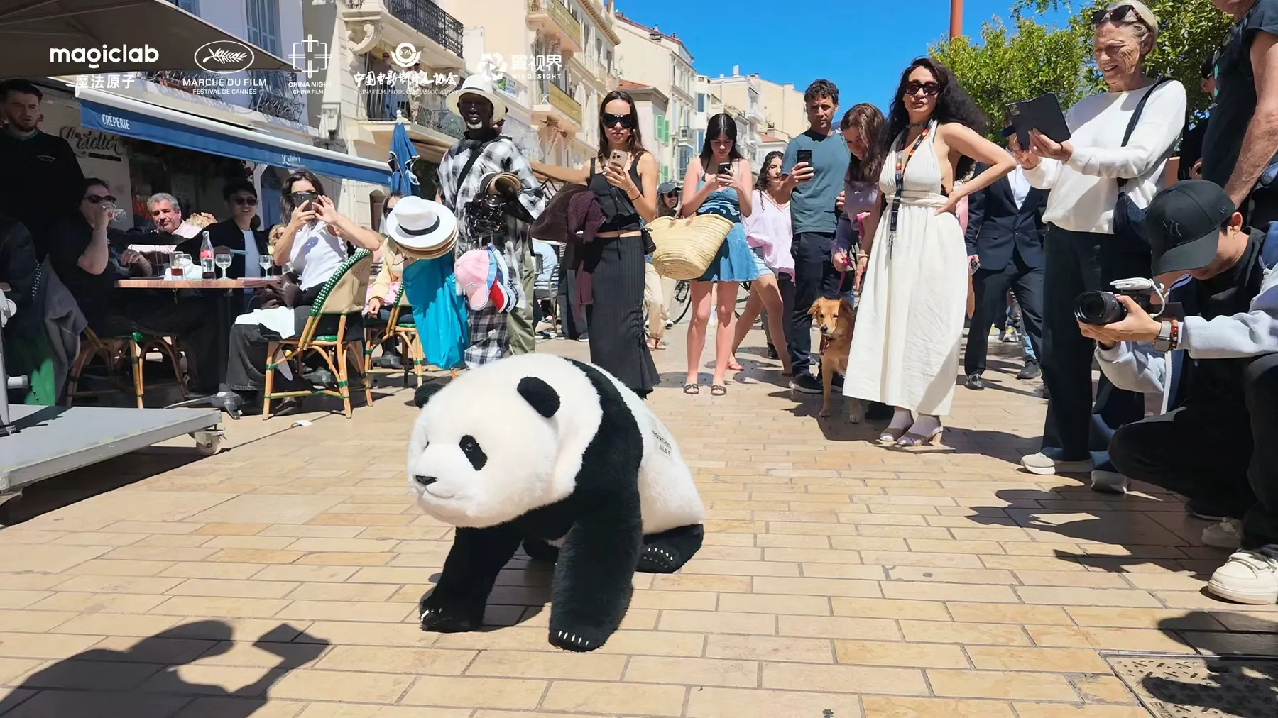 カンヌ国際映画祭の通りを歩く Magic Panda と、スマホを向ける人々