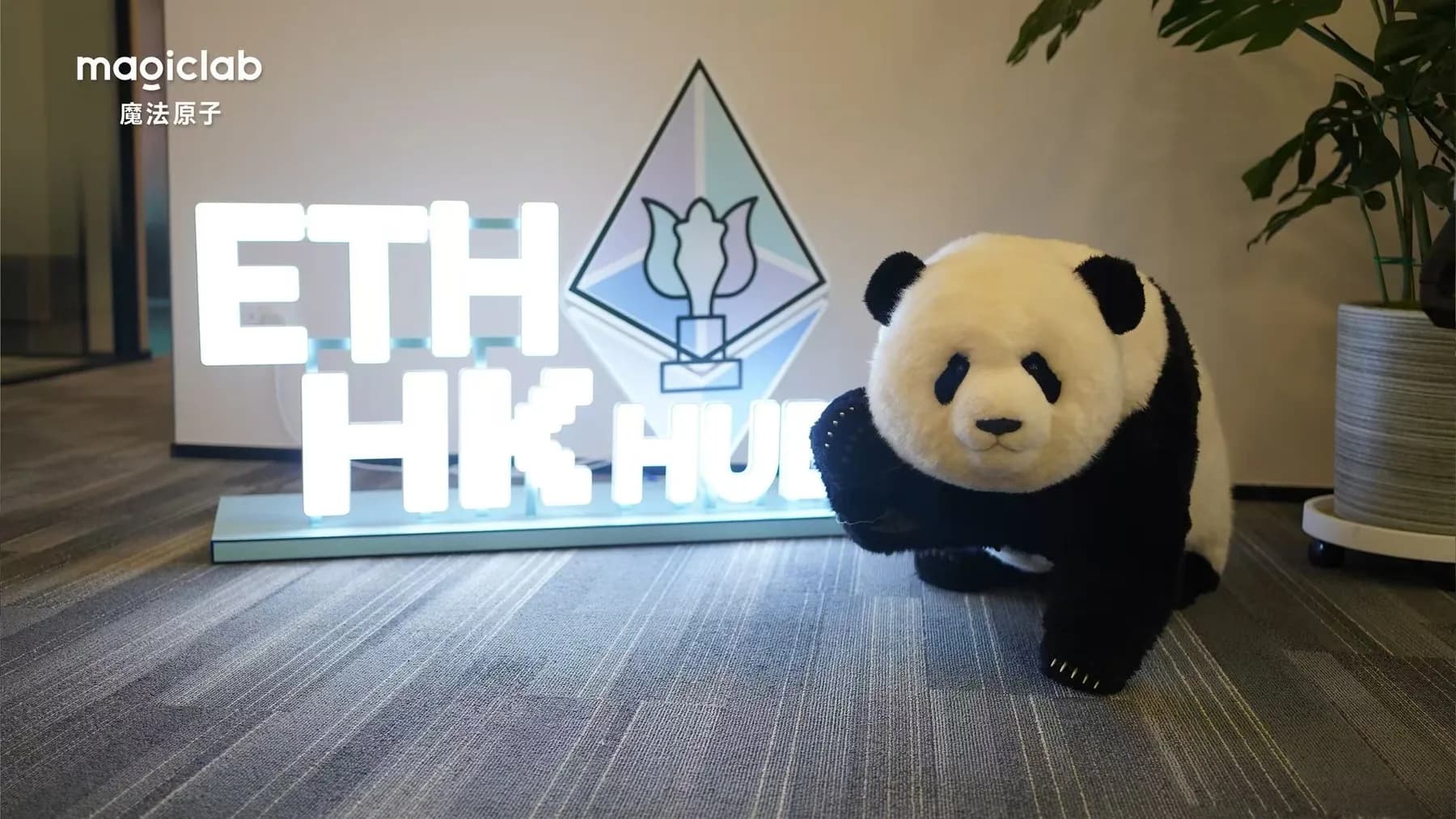 香港 ETH HK Hub のサイン横に立つ Magic Panda