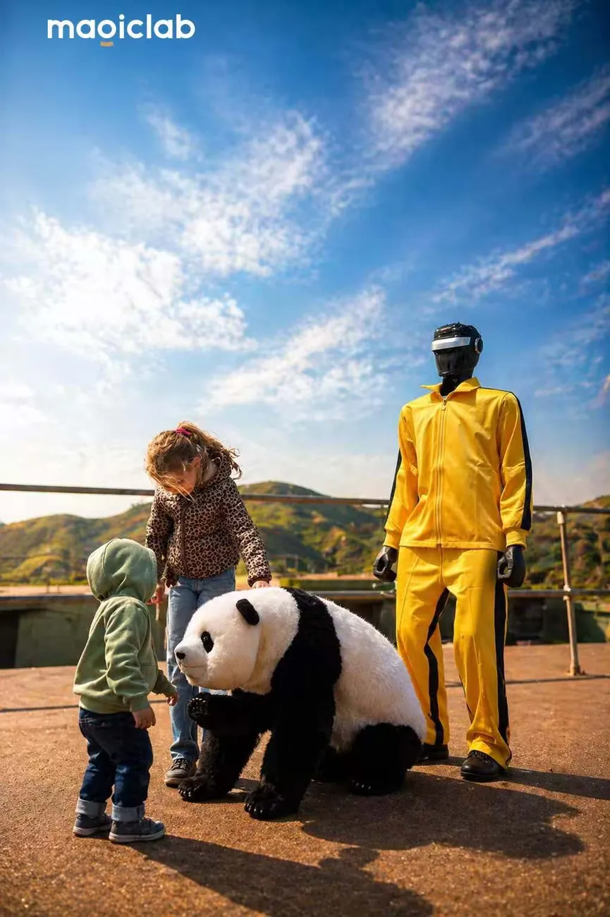 ヒューマノイドの隣で Magic Panda に触れる小さな子どもたち